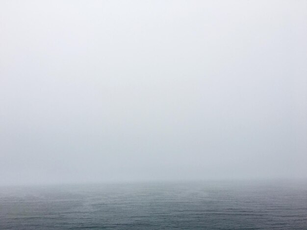 Photo scenic view of sea against sky during foggy weather