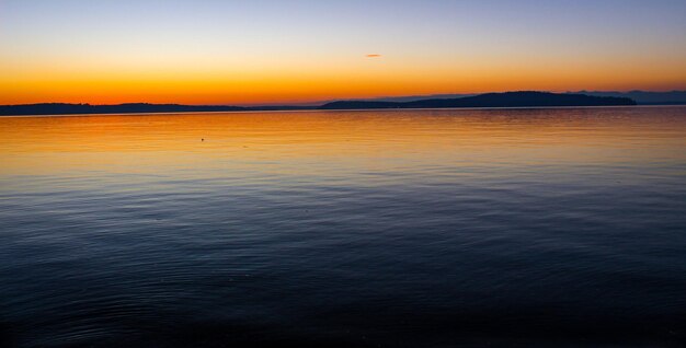 Photo scenic view of sea against sky at sunset