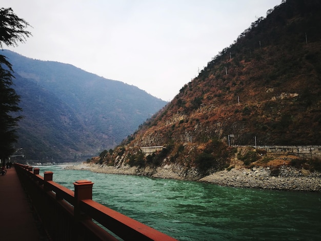 Photo scenic view of sea by mountains against sky