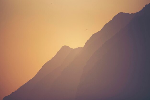 Photo scenic view of silhouette mountain against sky during sunset