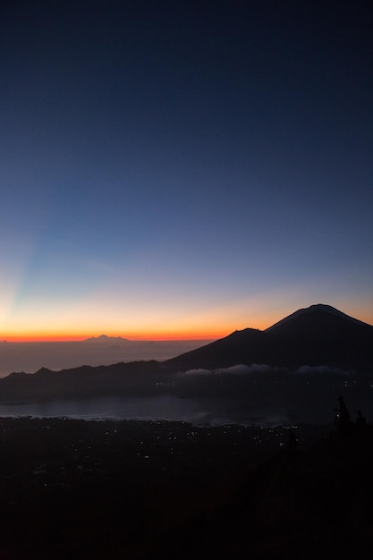 Photo scenic view of silhouette mountains against clear sky at sunset