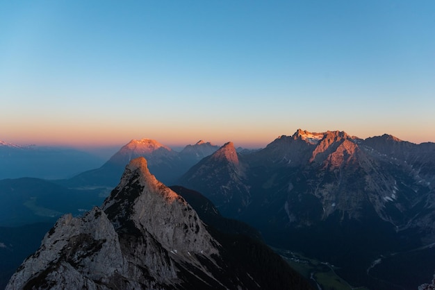 Photo scenic view of snowcapped mountains against clear sky during sunset