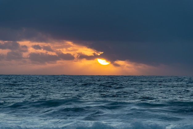 Scenic View of Sun behind Cloud at Sunset Time Over the OceanBackgroundsCopy Space