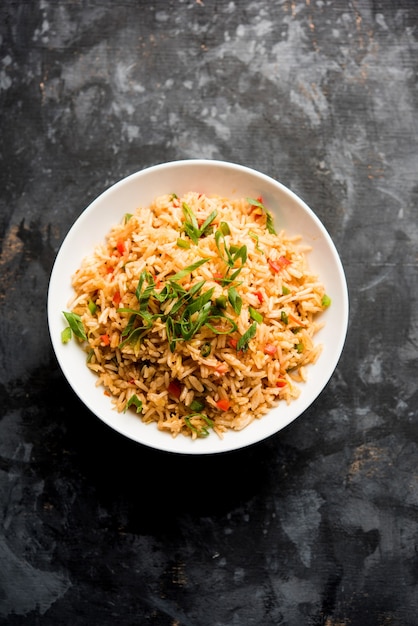 Schezwan Fried Rice Masala is a popular indo-chinese food served in a plate or bowl with chopsticks