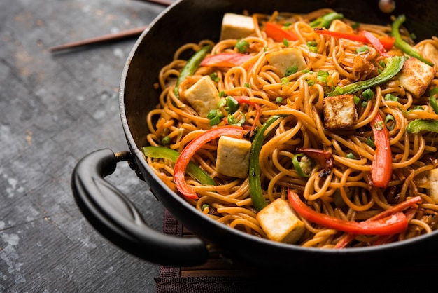 Schezwan hakka noodles with paneer or cottage cheese. Served in a bowl. selective focus