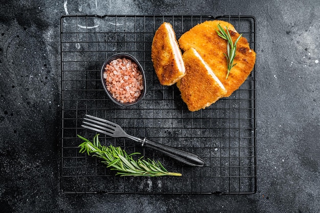 Schnitzel Cordon bleu fillet cutlet with ham and cheese Black background Top view