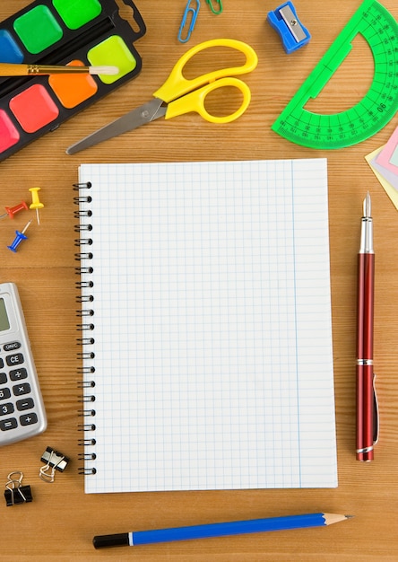 School accessories and checked notebook on wood texture