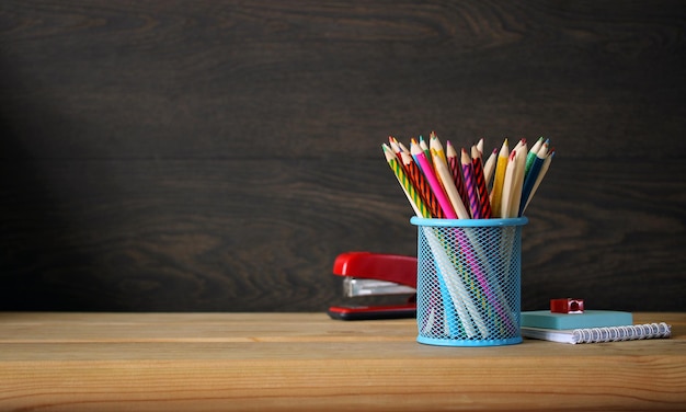 School background Colored pencils stapler and notepad