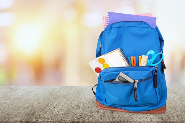 School bag on wooden background.