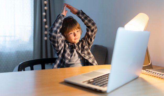 School boy taking online courses and gesturing