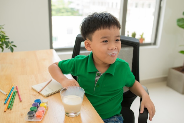 School child doing homework and drinking milk