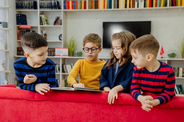 school children in the library reading books, doing homework, prepare a school project for lessons