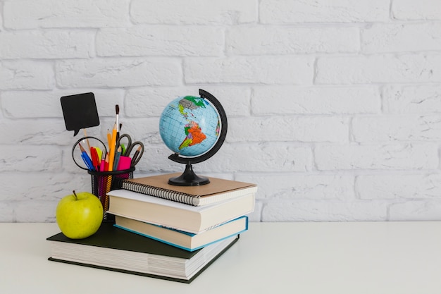 School composition with books, apple and world globe