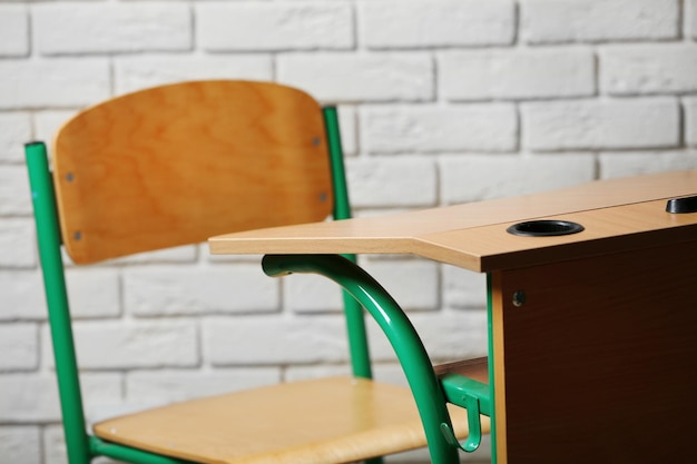 Photo school desk and chair on white brick wall background