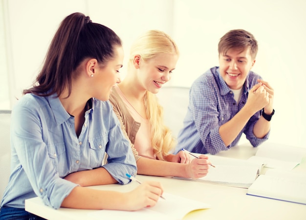 school and education concept - group of smiling students with notebooks at school