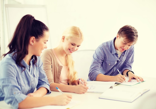 school and education concept - group of smiling students with notebooks at school