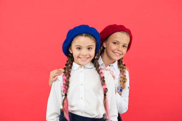 School friends Happy small girls friends on pink background Adorable friends enjoying friendship Little school friends smiling in uniform and stylish berets