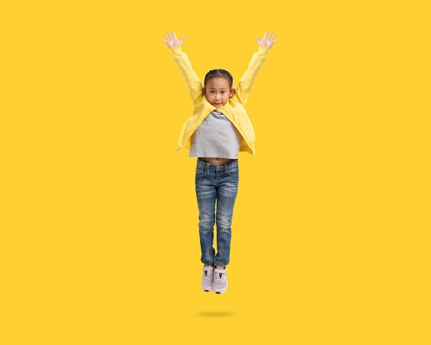 School girl Happy Asian student school kid jumping for joy Full body portrait isolate on yellow background with clipping path for design work