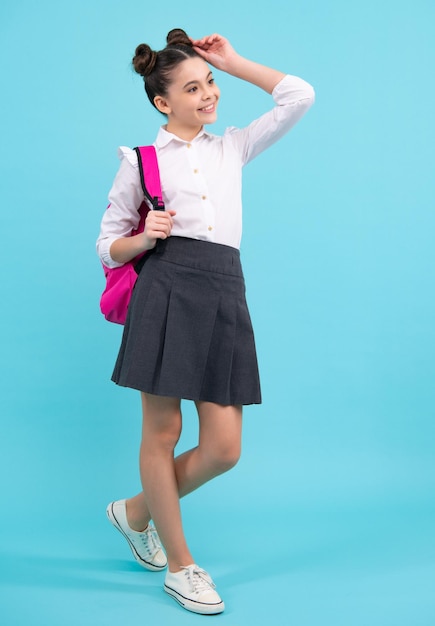 School girl in school uniform with backpack Teenage girl student on blue isolated background Learning knowledge and kids education concept