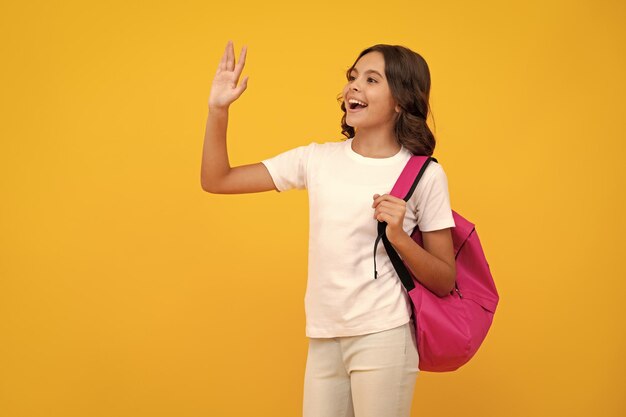 School girl in school uniform with school bag Schoolchild teenager hold backpack on yellow isolated background