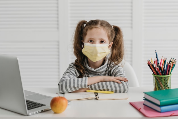 School girl wearing medical mask front view