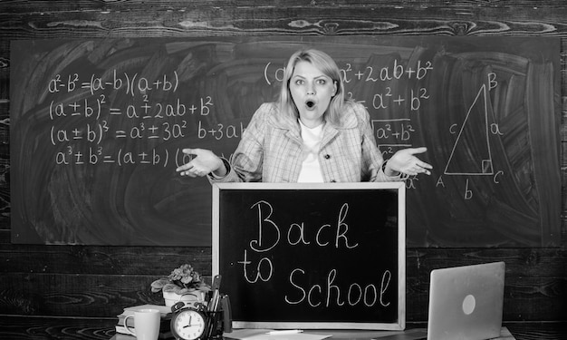 Photo school home schooling surprised woman back to school teachers day teacher with clock at blackboard time woman in classroom study and education modern school knowledge day look at this