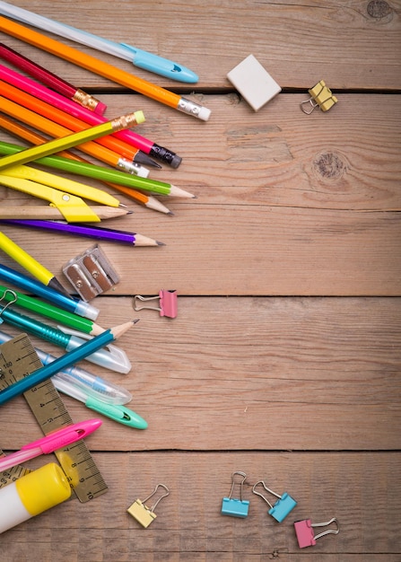 School items on a wooden table, Pencils and student pens on a wooden surface