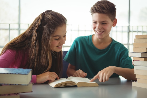 School kids reading books in library at school