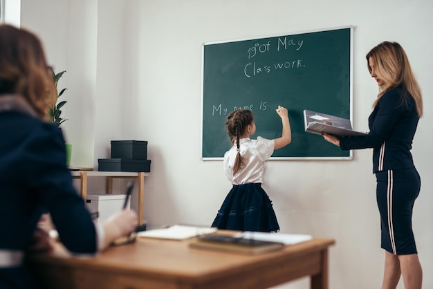 School lesson Teacher and pupil write on a blackboard