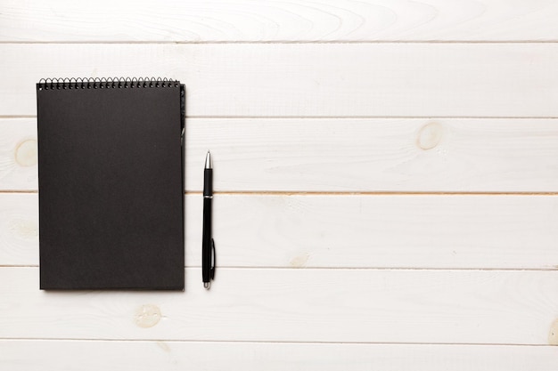 School notebook on a colored background spiral black notepad on a table Top view