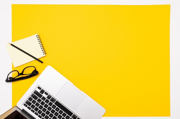 School and office supplies lie neatly on a yellow wall