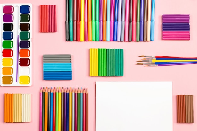 Photo school supplies arrangement on a pink background