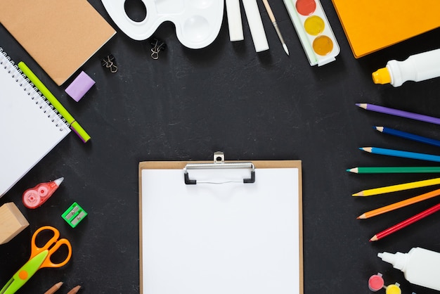 School supplies on black board background. Back to school concept. Frame, flatlay, copy space for text. mock up