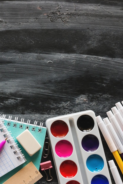 School supplies on a blackboard with space for text