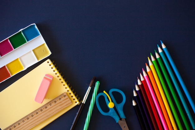 School supplies on dark blue background. 