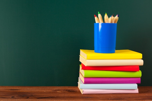 School supplies on a wooden table and blackboard