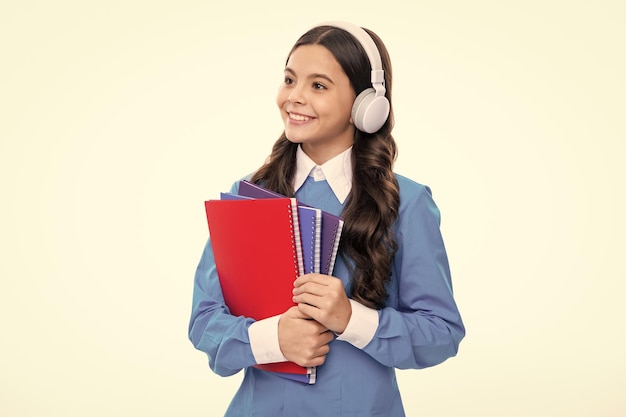 School teen girl in headphones and books copy space back to school