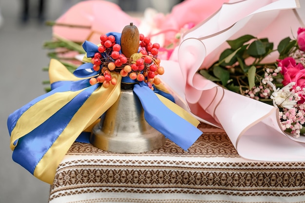 School traditional metal bell in yellow and blue ribbons Ukrainian first bell