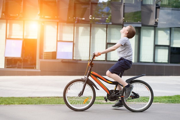 Schoolboy rides a bicycle. Summer holidays.