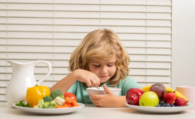 Photo schoolchild eating breakfast before school portrait of little teen child sit at desk at home kitchen