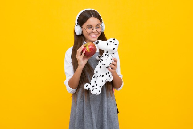 Schoolgirl 12 13 14 years old  toy School children cuddling favorite toys yellow background Happy