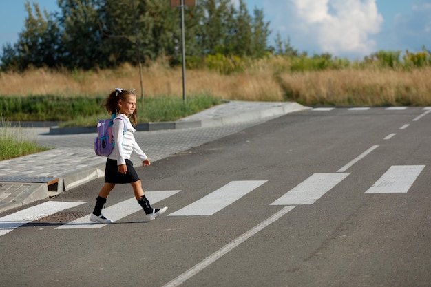 schoolgirl crosses the road at a pedestrian crossing