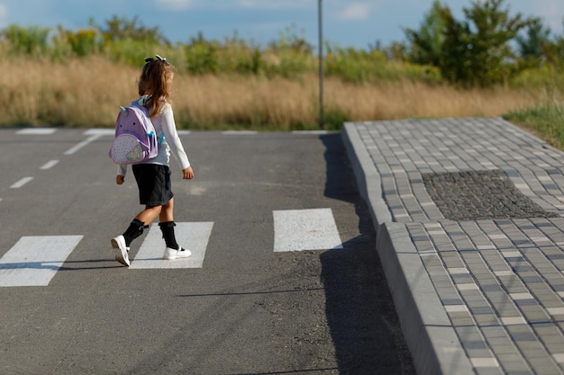 schoolgirl crosses the road at a pedestrian crossing