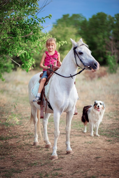 Schoolgirl girl rides a white pony A child riding a horse