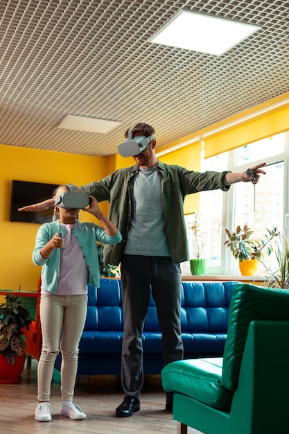 Schoolgirl playing in virtual reality with her teacher