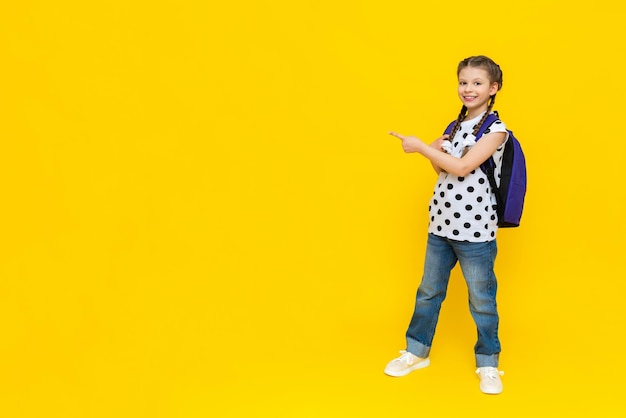 A schoolgirl shows her hands at an advertisement a beautiful schoolgirl goes to school with a briefcase a child with textbooks and notebooks goes to additional courses in a foreign language