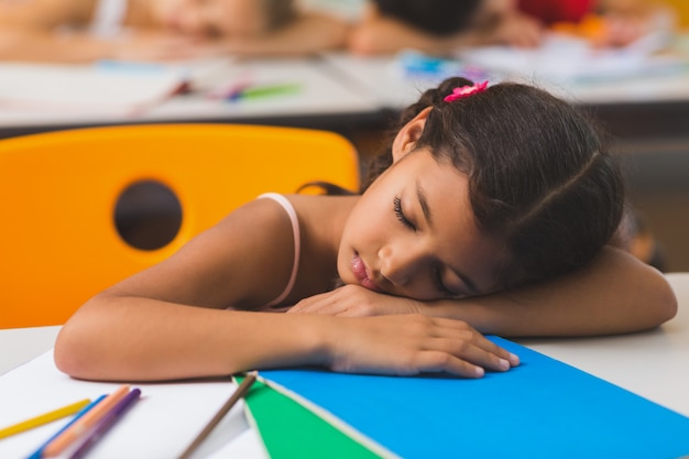 Schoolgirl sleeping at desk