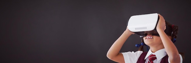 Photo schoolgirl using virtual reality headset against blackboard