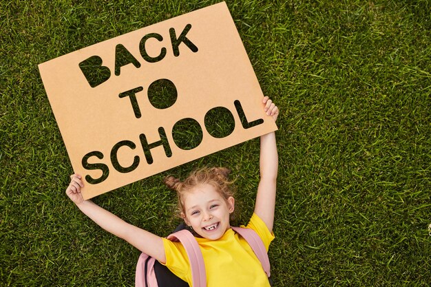 Schoolgirl with back to school placard