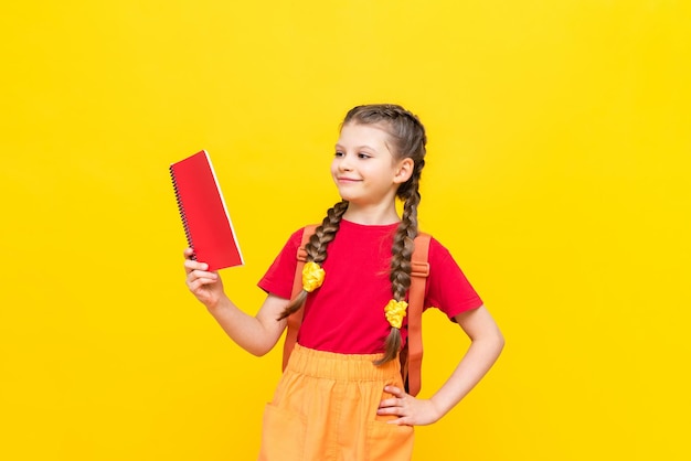 A schoolgirl with a satchel is getting ready to go to school Children's education Preparatory courses for schoolchildren Additional classes for successful exams Yellow isolated background